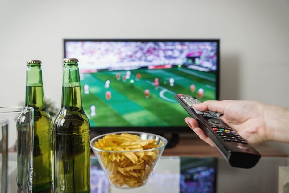 Person checking settings on a television with a remote