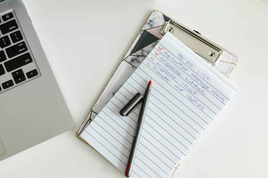 Checklist on a clipboard beside a pen