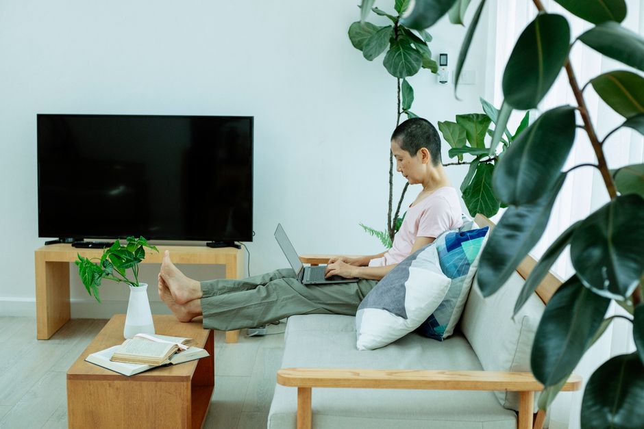 Person comparing options on a laptop in front of a television
