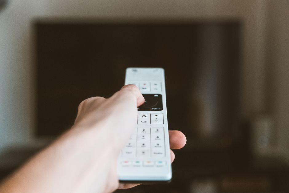 Streaming box and remote beside a television