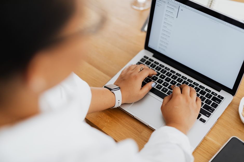 Person writing an email on a laptop