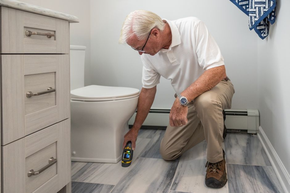 Licensed plumber working under a bathroom fixture